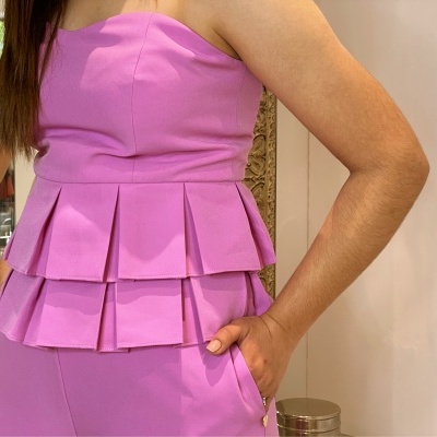 Top rosa com peplum e calças da mesma cor em tecido liso