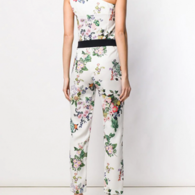 Macacão branco floral ombro a ombro com cinto preto e sapatos amarelos.