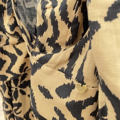 tecido com padrão animal print castanho e acessório dourado em forma de coração