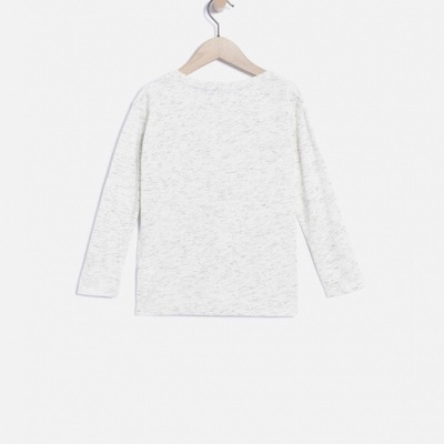 Camisola de manga comprida branca pendurada num cabide de madeira