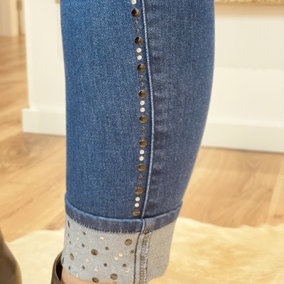 Calças de ganga azuis com botões prateados e barra dobrada com padrão de pontos