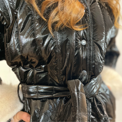 Casaco preto brilhante com botões prateados e cinto na cintura