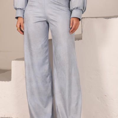 Conjunto de roupa cinzento claro com top cropped e calças largas em ambiente interior