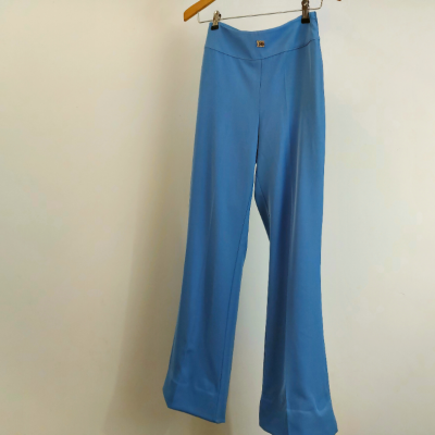 Calças azuis lisas penduradas num cabide de madeira