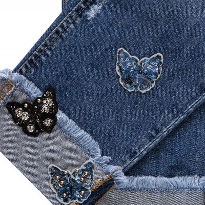 Calças de ganga azuis com borboletas em lantejoulas e bainha desfiada