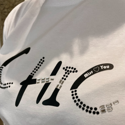 T-shirt branca com estampa preta e strass brilhantes, texto 'miss You' e padrão de pontos pretos