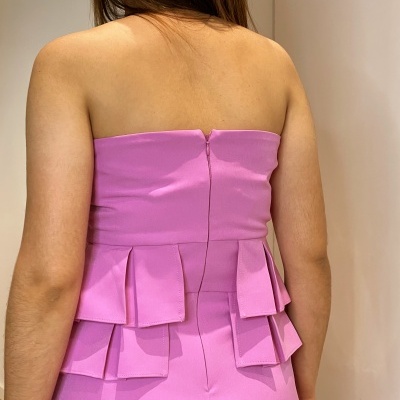 Vestido cor-de-rosa claro sem alças com babados na cintura visto das costas