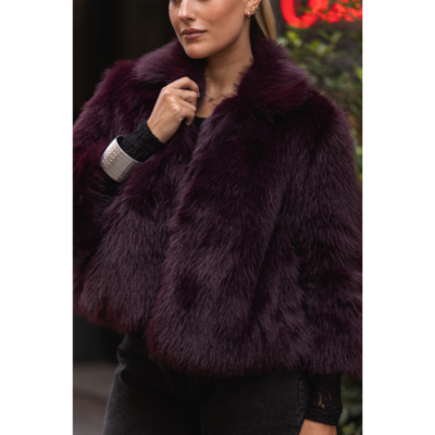 Casaco de pelo sintético bordô usado por mulher em ambiente exterior