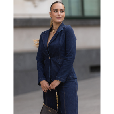 Mulher com fato de ganga azul escuro e mala castanha