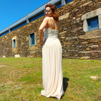 Vestido longo bege com renda na parte superior em ambiente exterior