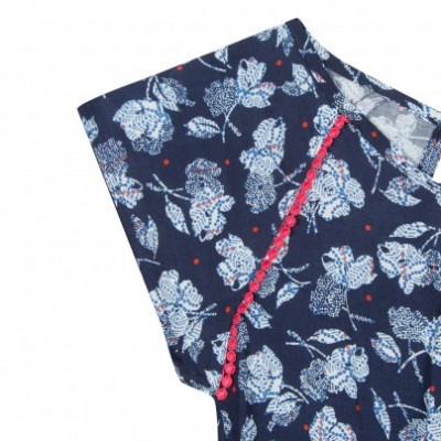 Peça de roupa azul com padrão floral branco e pontos vermelhos, costura vermelha com botões