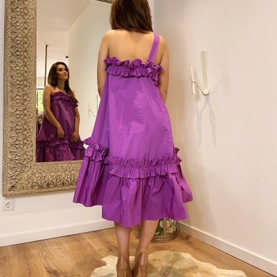 Vestido feminino roxo com babados em ambiente interno com espelho e chão em madeira