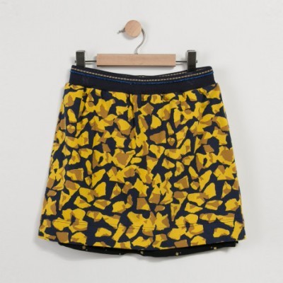 Saia feminina com padrão abstrato amarelo, castanho e preto em cabide