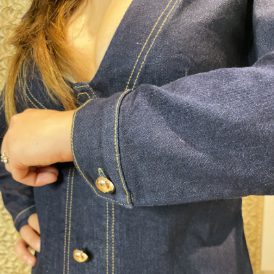 Casaco azul escuro de ganga com costuras amarelas e botões prateados