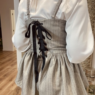 Vestido cinza listrado com fita preta entrelaçada nas costas sobre camisa branca