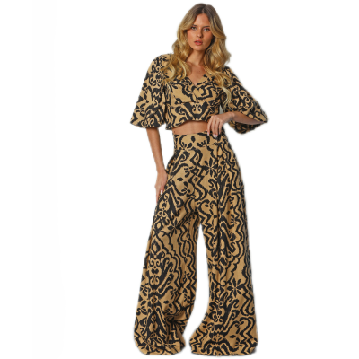 Conjunto feminino bege com padrão preto abstrato, camisa de manga curta e calças largas