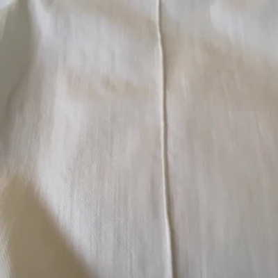 Calças brancas com botão perolado e detalhe de bolso