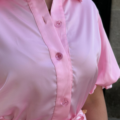 Blusa rosa claro com botões transparentes cor-de-rosa e mangas curtas franzidas