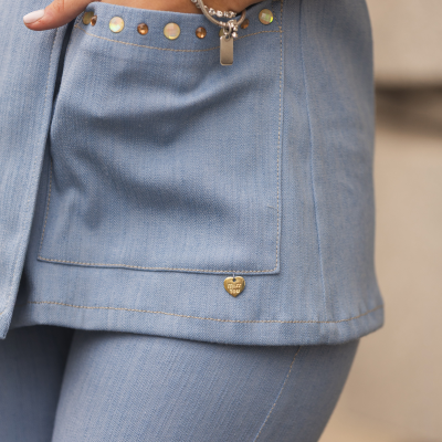 Conjunto azul claro com bolso decorado e pulseira dourada no pulso