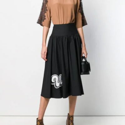 Conjunto feminino com blusa castanha de manga rendada preta e saia preta com logo branco e bolsa preta