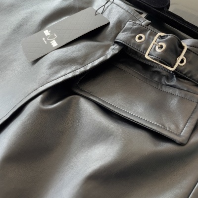 Calças pretas de material sintético com cinto e etiqueta SKIP