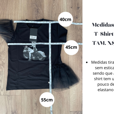 T-shirt preta XS com estampado de mota e mangas de tule sobre piso de madeira