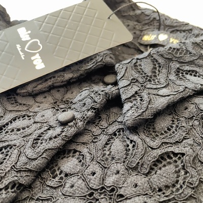 Blusa preta em renda floral com etiquetas de marca