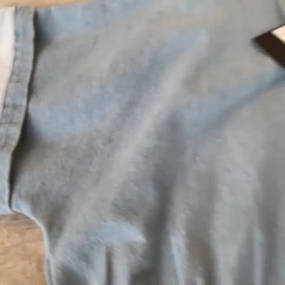 Camisa de ganga azul clara com botões e detalhe inferior em ganga escura