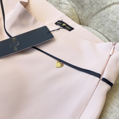 Saia rosa clara com detalhes pretos e pendente dourado em forma de coração