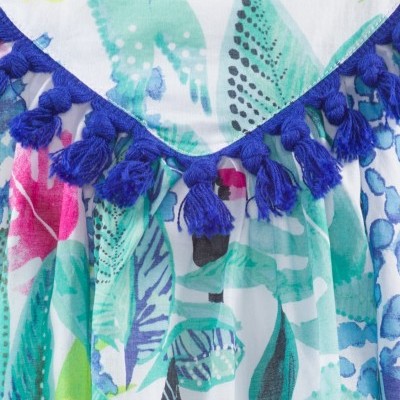 Roupa colorida com padrão de folhas e franjas azuis no decote