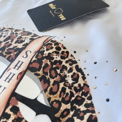 Pano branco com estampa colorida de boca com batom leopardo e etiqueta preta com texto dourado