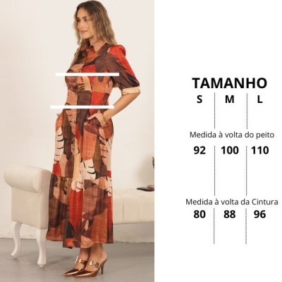 Vestido comprido padrão geométrico tons terra usado por mulher ao lado de sofá branco com gráfico de tamanhos.