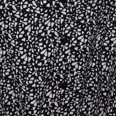 Camisa preta com padrão branco irregular e botões centrais