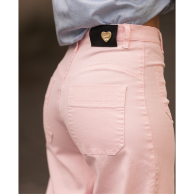 Calças rosa com bolso e etiqueta preta com coração dourado.