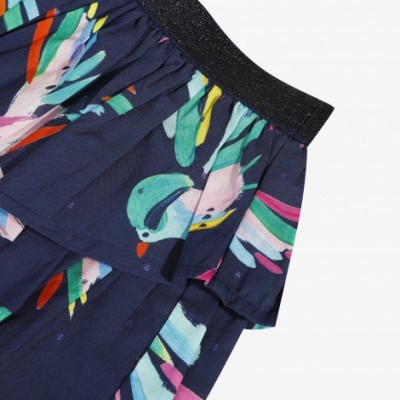 Detalhe de saia ou vestido azul com padrão de pássaros e cinto elástico preto.