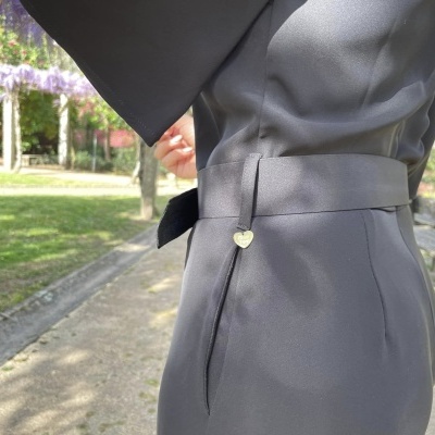Vestido cinzento com cinto e fivela em coração ao ar livre em jardim