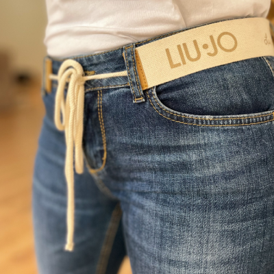 Calças de ganga azul com cinto bege e etiqueta LIU·JO
