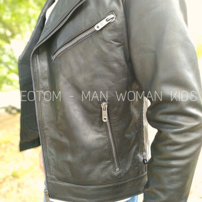 Casaco couro preto com fechos metálicos num ambiente exterior