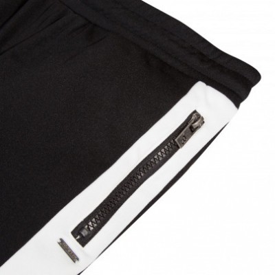 Detalhe de peça de roupa preta com faixa branca e fecho de correr