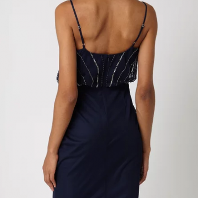 Vestido justo azul escuro com alças finas e detalhes brilhantes usado por uma mulher vista de costas