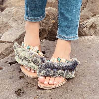 Sandálias abertas femininas com franjas multicoloridas, pérolas e pedras decorativas.