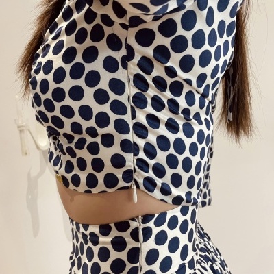 Conjunto de top e saia com padrão de bolinhas pretas e brancas