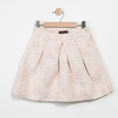 Saia rosa claro com padrão floral texturizado pendurada num cabide de madeira