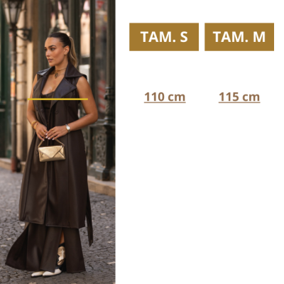 Mulher com casaco longo castanho escuro e bolsa dourada numa rua com calçada