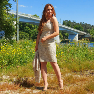 Mulher a usar vestido justo bege texturizado em ambiente natural junto a um rio