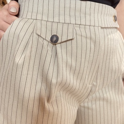 Calças bege com riscas pretas verticais e bolso com botão