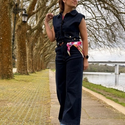 Mulher a usar conjunto de ganga preto com lenço rosa à cintura e óculos de sol