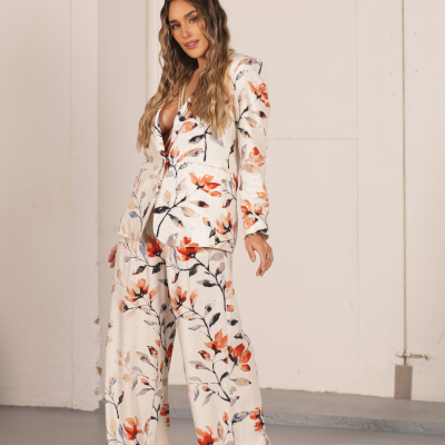 Fato feminino de tecido com padrão floral em tons de bege, laranja, castanho e preto