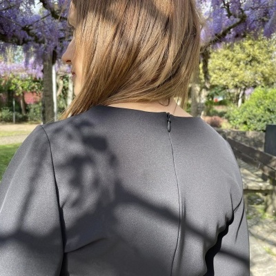Vestido cinzento liso visto de trás ao ar livre num jardim
