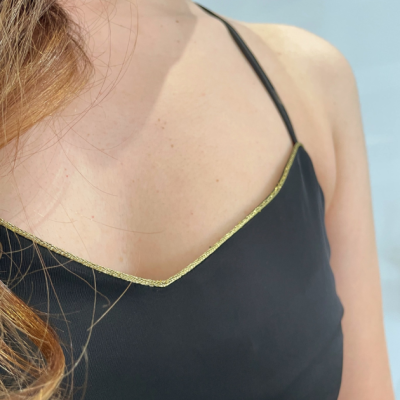 Blusa preta com alças finas e acabamento dourado na borda superior